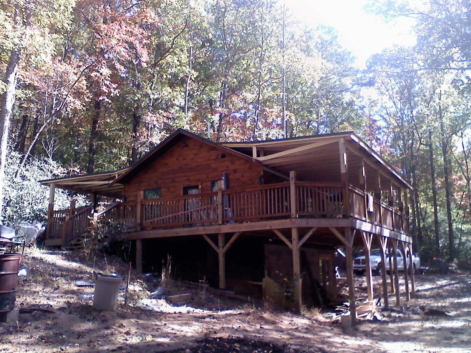 Log cabin with a wraparound porch and metal roof in the fall in Washington